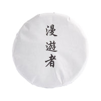 The Wanderer sheng puerh cake in its paper wrapper