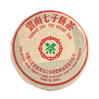 1999 "8582" sheng puerh cake in its paper wrapper