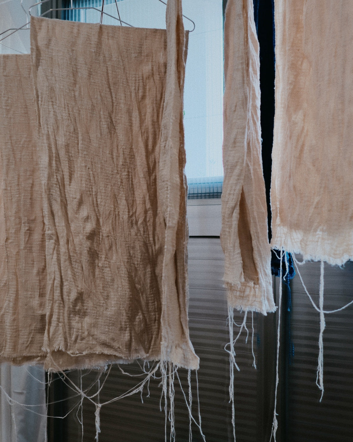 Undyed hemp cloth hanging in the studio before dyeing